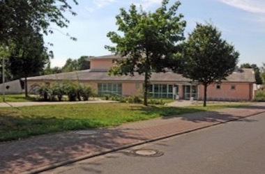 Rötliches Gebäude mit Bäumen davor in Florstadt im Wetteraukreis